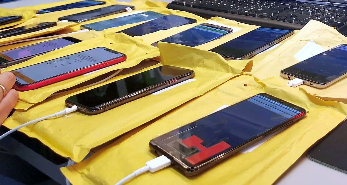 A bench of handsets cabled up and running, each on its own padded mat