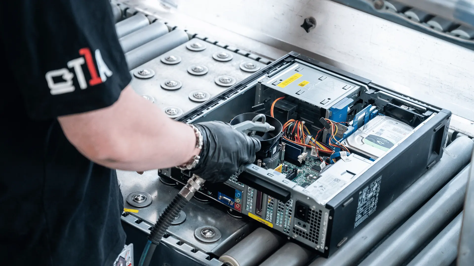 Un technicien travaillant sur un ordinateur de bureau ouvert sur la ligne à rouleaux